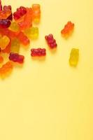 Colored jelly bears on an yellow background with copy space. Top view photo