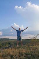 The man raised his hands to the side and enjoys the view of nature photo