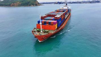 antenne in vooraanzicht van vrachtschip met container en rennend met sleepboot voor exportgoederen van vrachtwerfhaven naar aangepast oceaanconcept vrachtvervoer per schip. video