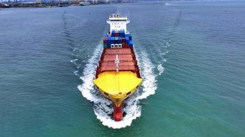 antenn framifrån av lastfartyg som transporterar container och kör med bogserbåt för exportgods från lastgårdshamn till anpassad havskoncept fraktfrakt med fartyg.