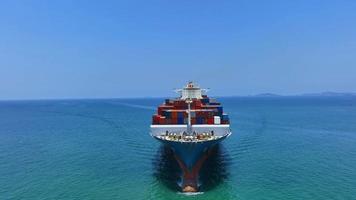 Antenne in der Vorderansicht des Frachtschiffs, das Container trägt und mit Schlepper für Exportgüter vom Frachthafen zum benutzerdefinierten Ozeankonzept läuft Frachtversand per Schiff. video