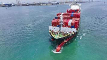 antenne in vooraanzicht van vrachtschip met container en rennend met sleepboot voor exportgoederen van vrachtwerfhaven naar aangepast oceaanconcept vrachtvervoer per schip. video