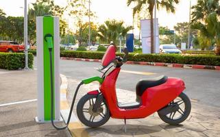 un scooter eléctrico cargando en la central eléctrica foto