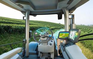 5G autonomous tractor working in tea field, Future technology with smart agriculture farming concept photo