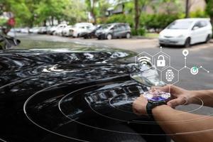 hombre que usa un reloj inteligente para desbloquear la puerta del auto con conexión inalámbrica, concepto de tecnología futura foto