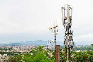 Telecommunication tower with 5G cellular network antenna on A town in the valley background photo