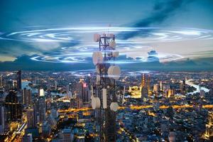 Telecommunication tower with 5G cellular network antenna wave on night city background photo