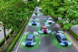 Smart cars with automatic sensor driving on green road with wireless connection photo