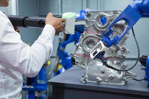 Engineer and assistant robot working with 3D portable measuring scan automotive part in factory, Industry 4.0 concept photo