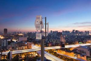 Telecommunication tower with 5G cellular network antenna on night city background photo