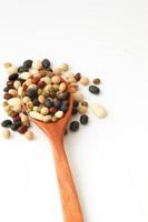 Grains, Five colors of red, white, black, yellow and green beans on wooden spoon with white background. photo