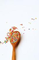 Sugar flakes on wooden spoon with white background. photo