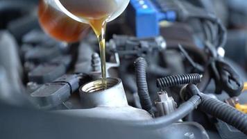 Pouring fresh new clean synthetic oil into the car engine.