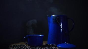 coffee bean on the old wooden floor and an enamel mug of coffee with smoke. set of coffee with pot. soft focus. video