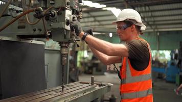 industriingenjörer i hårda hattar.jobbar på den tunga industrins tillverkningsfabrik. industriarbetare inomhus i fabrik. man som arbetar i en industri video