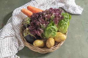 Healthy food vegetable red lettuce and romaine eggplant carrot potato on green wood table, top view, copy space. photo