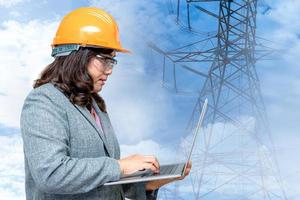Asian engineer woman standing and use notebook computer to planning work at high voltage power station. photo