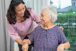 ayude a la anciana asiática o anciana sentada en silla de ruedas y usando una máscara facial para proteger la infección de seguridad covid 19 coronavirus. foto