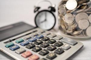 Save money coins in grass jar with calculator, Business finance investment concept. photo