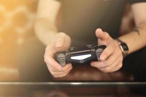 Playing games concept. Part body man with joystick play game on console. Male hands holding pad. High quality photo