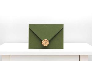 green envelope with designer cardboard and seal on a white background. Envelope with seal photo