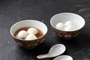 Bola de masa dulce de tang yuan hecha de glutinoso relleno de sésamo negro en almíbar de jengibre. foto