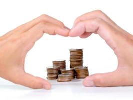 Saving money with stacks of coins for growing your life and couple hands making heart shape on white background. photo