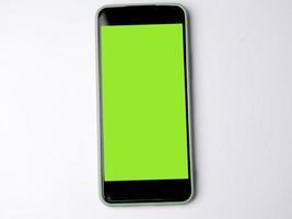 Smartphone with green screen and modern design isolated on white background. photo