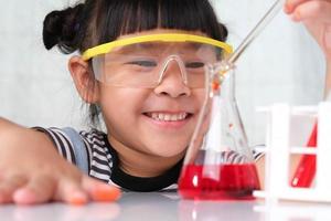 Children are learning and doing science experiments in the classroom. Little girl playing science experiment for home schooling. Easy and fun science experiments for kids at home. photo