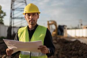 hombre ingeniero trabajando en el sitio de construcción. hombre joven trabajador que trabaja en el sitio de construcción. concepto de ingeniería y construcción. foto