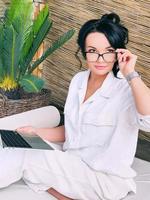 Beautiful woman entrepreneur freelancer in glasses work remotely. Education, travel, business concept photo