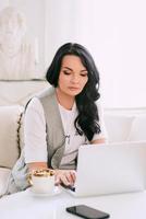 mujer sentada en el sofá y tomando notas en su cuaderno. negocios, análisis, educación foto