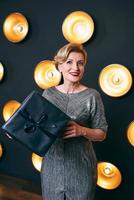 beautiful mature woman with black present gift box. Party, celebration concept photo
