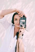 portrait of beautiful woman photographer holding film camera. occupation, travel concept photo