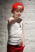 Portrait of cool young hip hop boy in red hat and red pants and white shirt in the loft photo