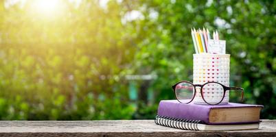 Back to school background with books, pencil and ruler on green blurred backgrounds with copy space. photo