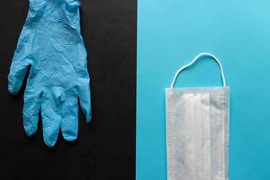 Medical mask and latex glove on a black and blue background. Virus protection concept. Safe delivery. Donation. Stay safe photo