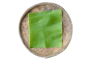 Green banana leaves on a bamboo tray photo