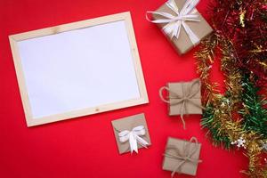 Gift Box and Note Book on Red Christmas Background photo