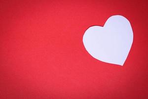 papel blanco en forma de corazón sobre un fondo rojo con el concepto de día de san valentín foto