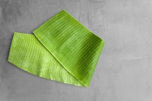 Banana leaves set against gray cement background . photo