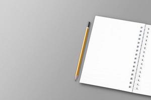 A white notebook and pencil are placed on a white paper surface. photo