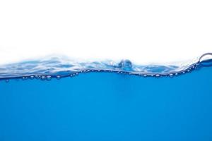 superficie de agua azul en movimiento y burbujas en un fondo blanco foto