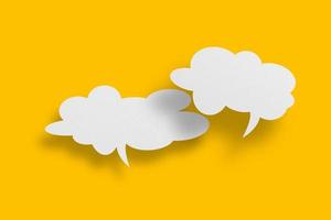 White paper in speech bubble shape set against yellow background. photo