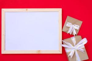 Blank frame and gift box on red ground for Christmas and celebrations. photo