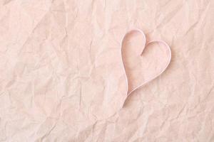 Pink paper hearts on brown paper background photo