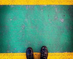 Old safety shoes on yellow-green floor in factory area and design space for your design. photo