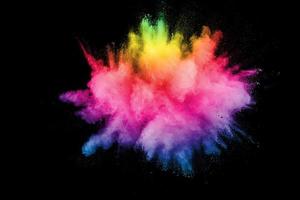 Abstract multicolored powder explosion on black background. Color dust particle splattered on background. photo