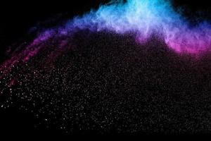 explosión de polvo multicolor sobre fondo negro. explosión de polvo azul rojo. foto