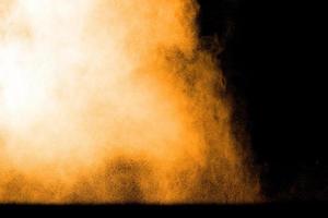 Orange color powder explosion on black background. photo
